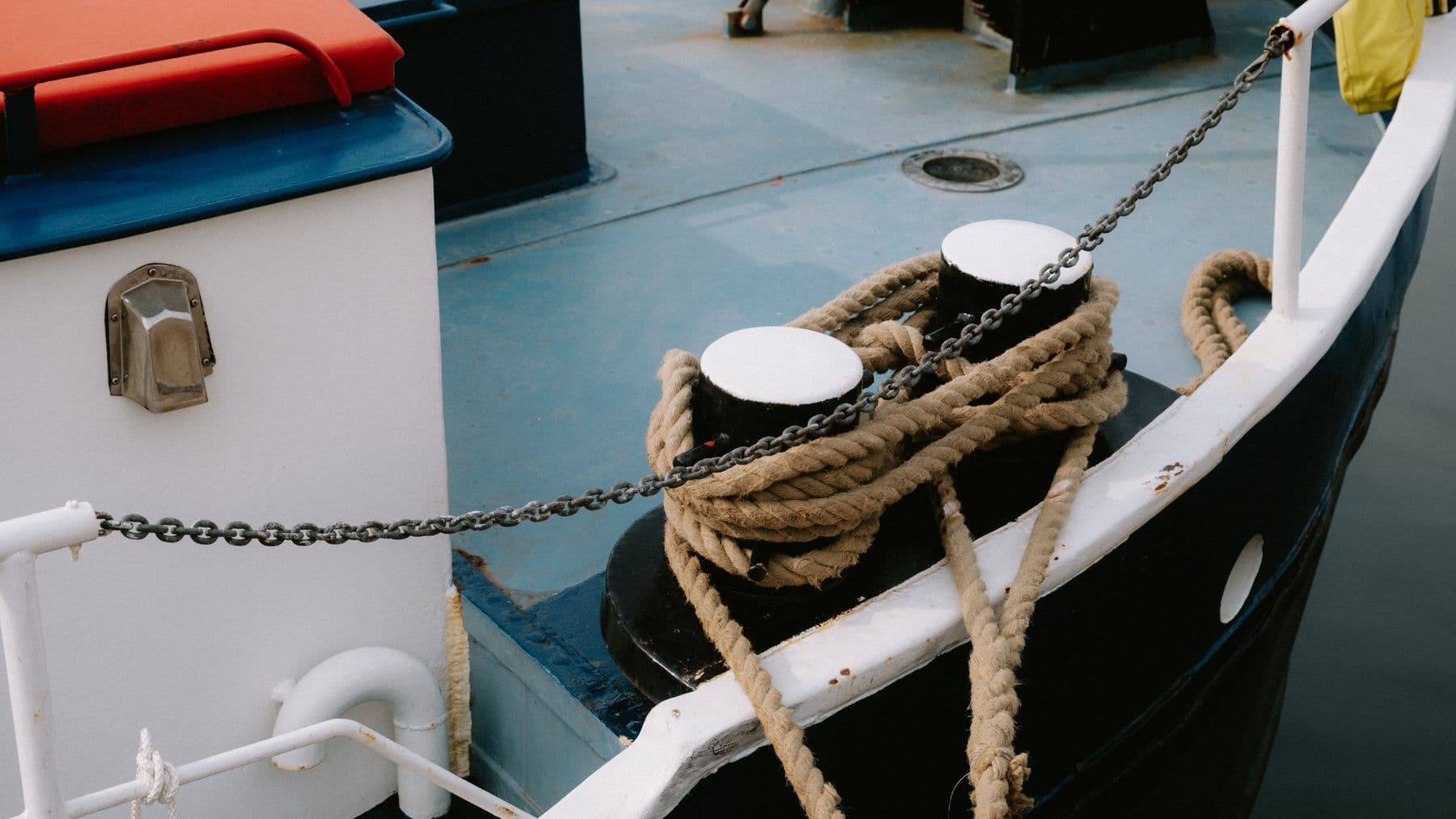 Detailed view of a boat deck showcasing robust mooring ropes and chain, ideal for marine-themed content.